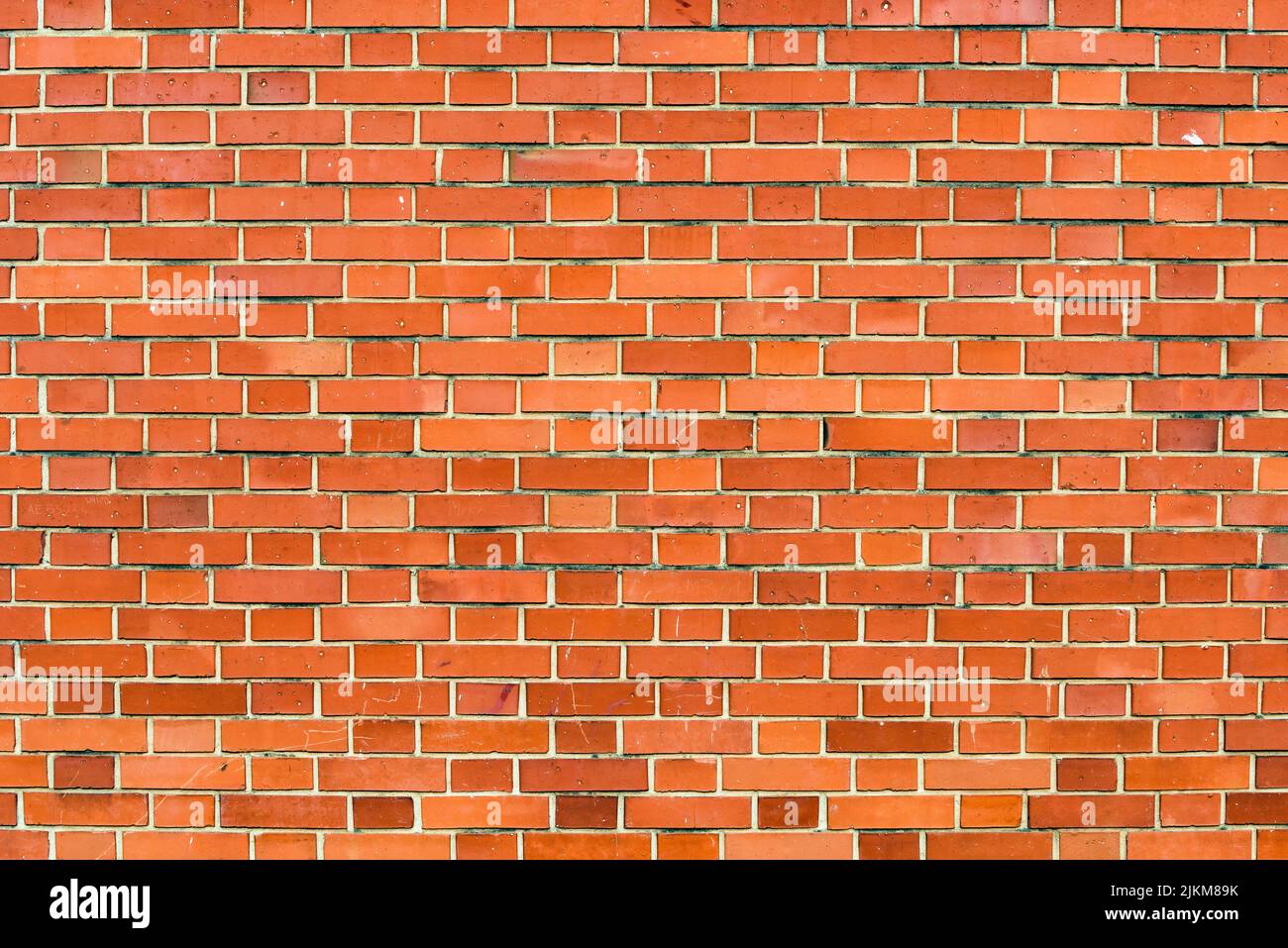 Sfondo muro di mattoni rossi. Scatto orizzontale di motivi in muratura come elemento grafico testurizzato. Dettagli sulla facciata urbana. Foto Stock