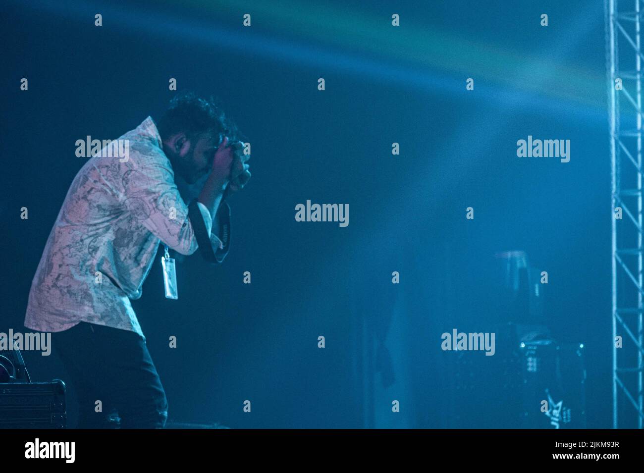 Un'immagine di un fotografo che scatta foto con una fotocamera professionale durante una performance dal vivo ad Assam, India Foto Stock