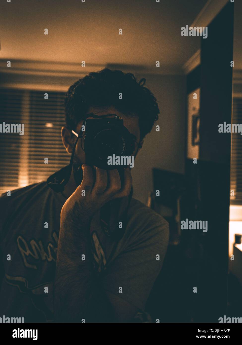 Uno scatto verticale di un bell'uomo che fotografa se stesso nello specchio Foto Stock