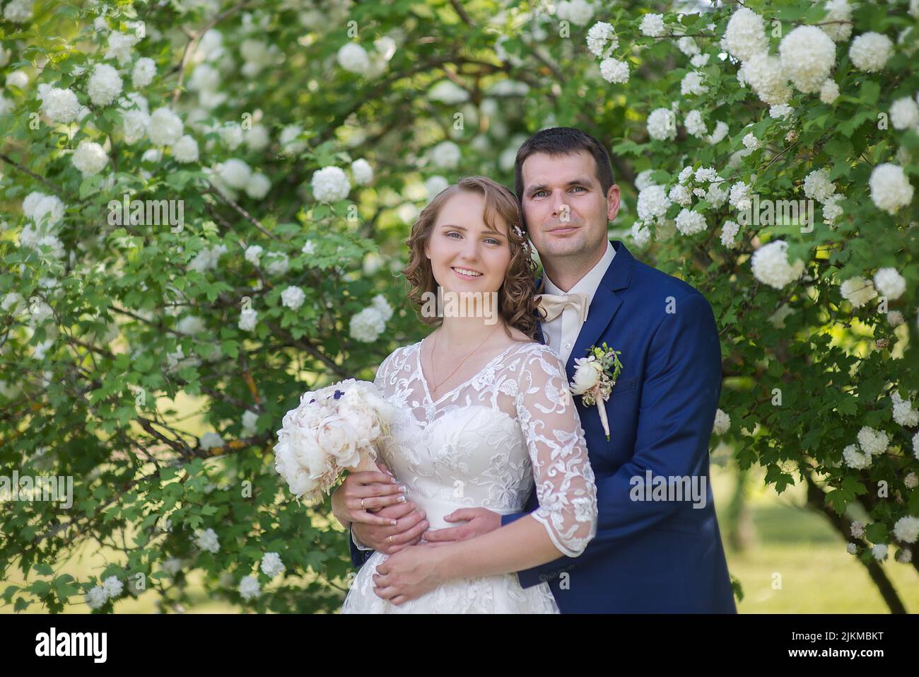 Un primo piano di sposi caucasici durante le loro nozze giardino Foto Stock