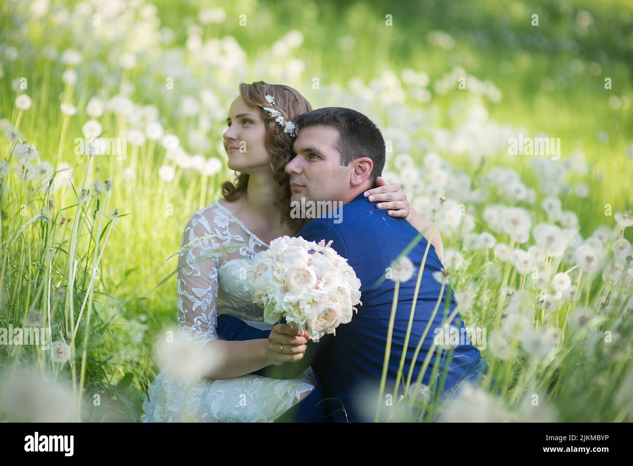 Un felice sposi novelli in un campo di dente di leone Foto Stock