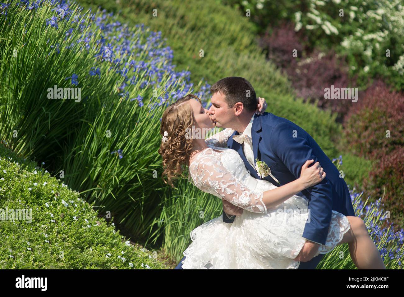 Una splendida vista di sposi novelli che si baciano nel parco Foto Stock