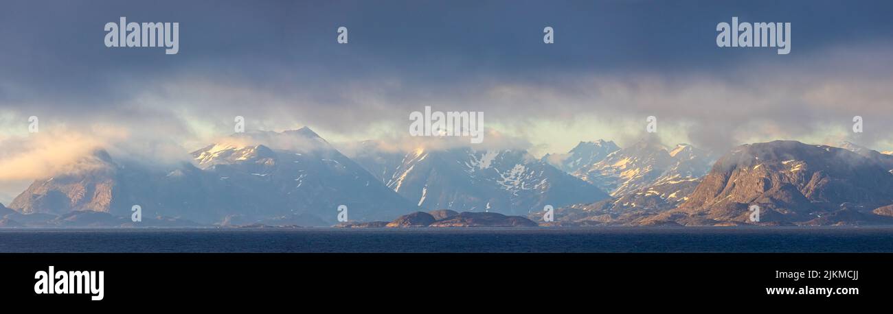 Panorama delle montagne artiche della Groenlandia bagnata dalla luce del tramonto dal mare di Labrador Foto Stock