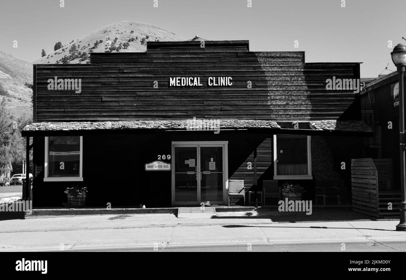 Un'immagine in scala di grigi dell'esterno di una vecchia clinica medica a Jackson Hole, USA con un cielo grigio Foto Stock