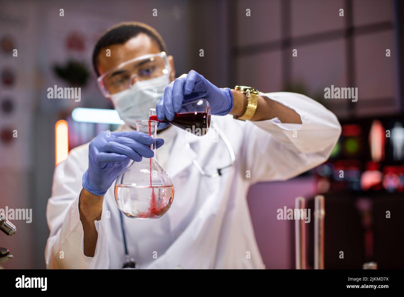 Scienza, chimica, tecnologia, biologia e concetto di persone - giovane uomo afroamericano in maschera protettiva e occhiali scienziato con provetta e microscopio facendo ricerca in laboratorio clinico. Foto Stock