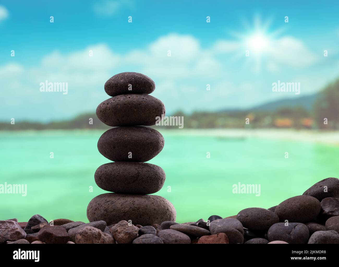 Concetto Zen. Accatastate pietre in fila sulla spiaggia tropicale. Foto Stock