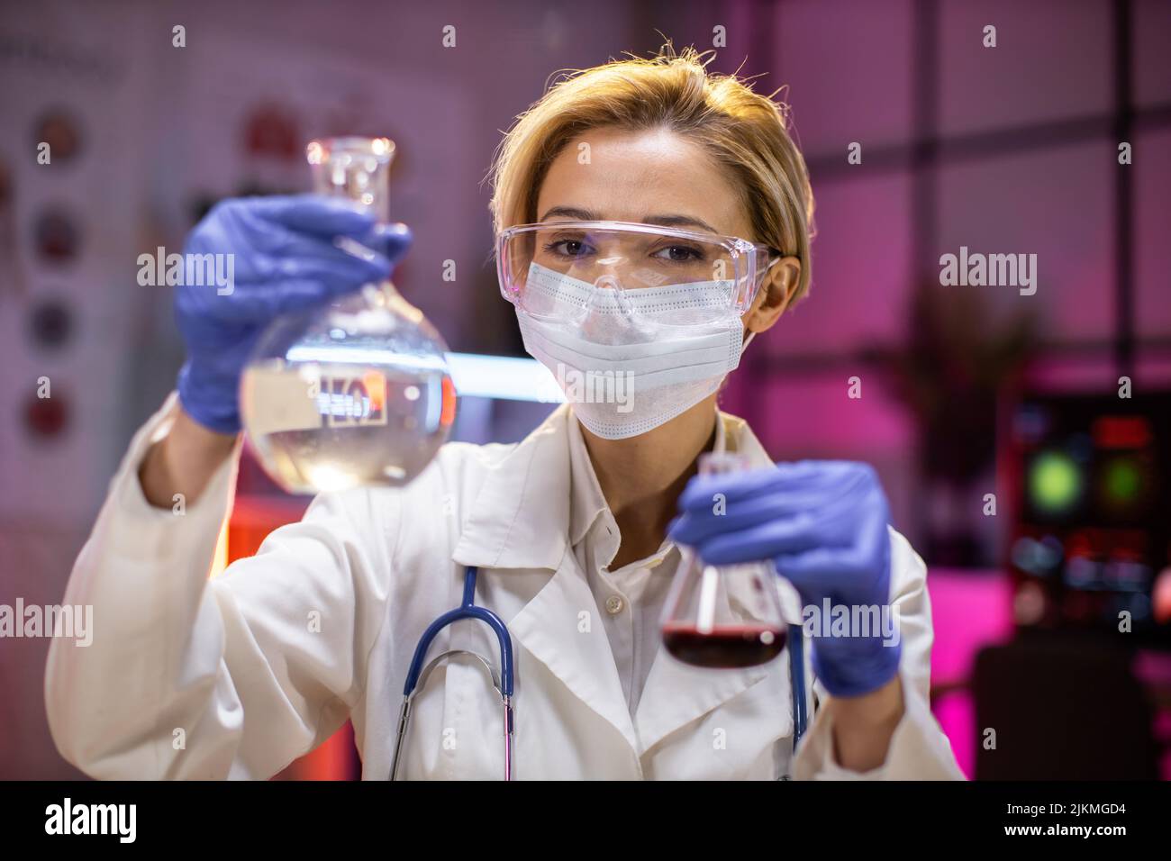 Giovane scienziata donna laboratorio tecnico di servizio che contiene matraccio con vetreria da laboratorio e provette in laboratorio chimico background, scienza laboratorio ricerca e sviluppo farmaci. Foto Stock