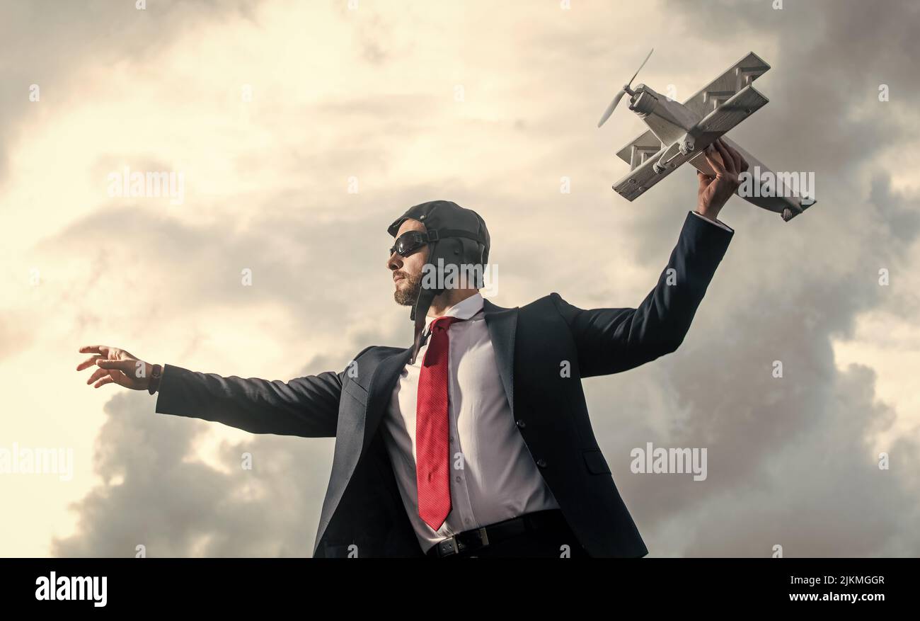 uomo d'affari in abito e cappello pilota lancia giocattolo aereo. idee Foto Stock