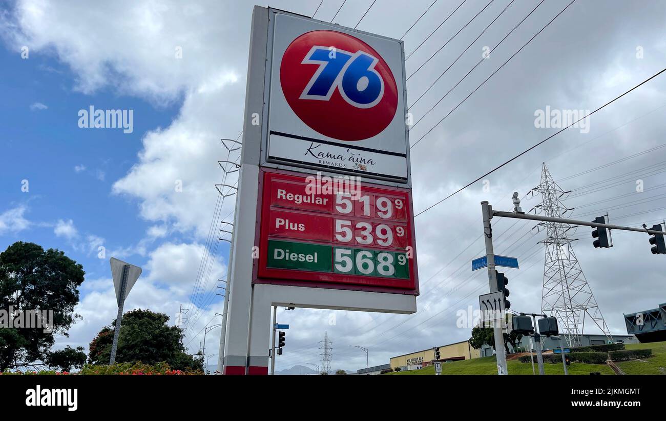 Un colpo d'angolo basso di un segno di strada dei prezzi del gas contro cielo nuvoloso blu in una giornata di sole a Pearl City, Oahu, Hawaii, Stati Uniti Foto Stock