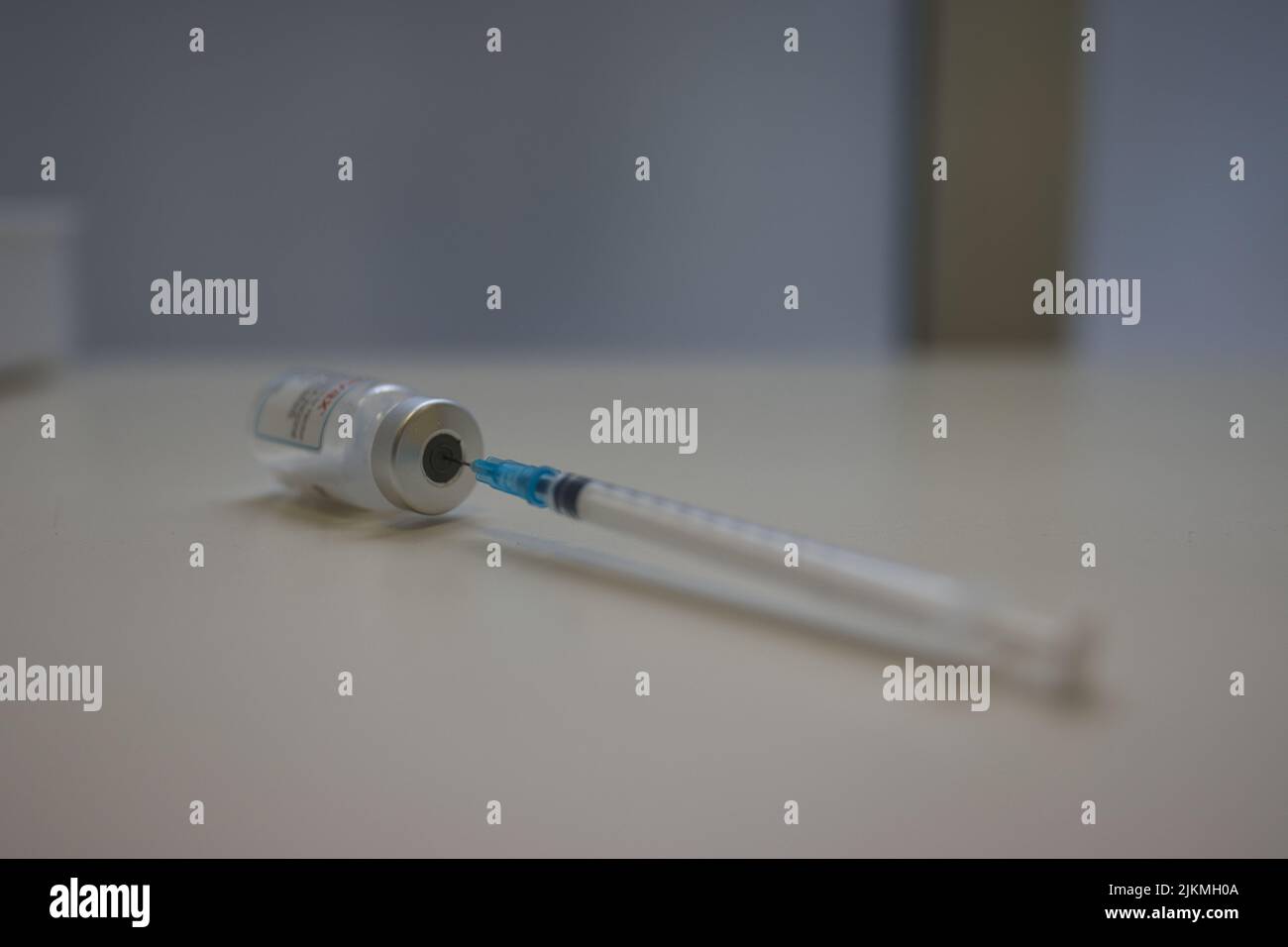 Un primo piano di una siringa per iniezione medica e di un flacone di vaccino per il covid-19 Foto Stock