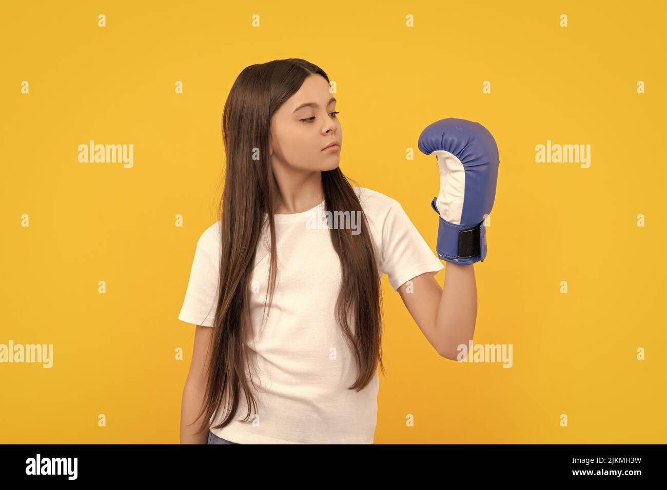 i bambini guardano i guanti da boxe su sfondo giallo Foto Stock