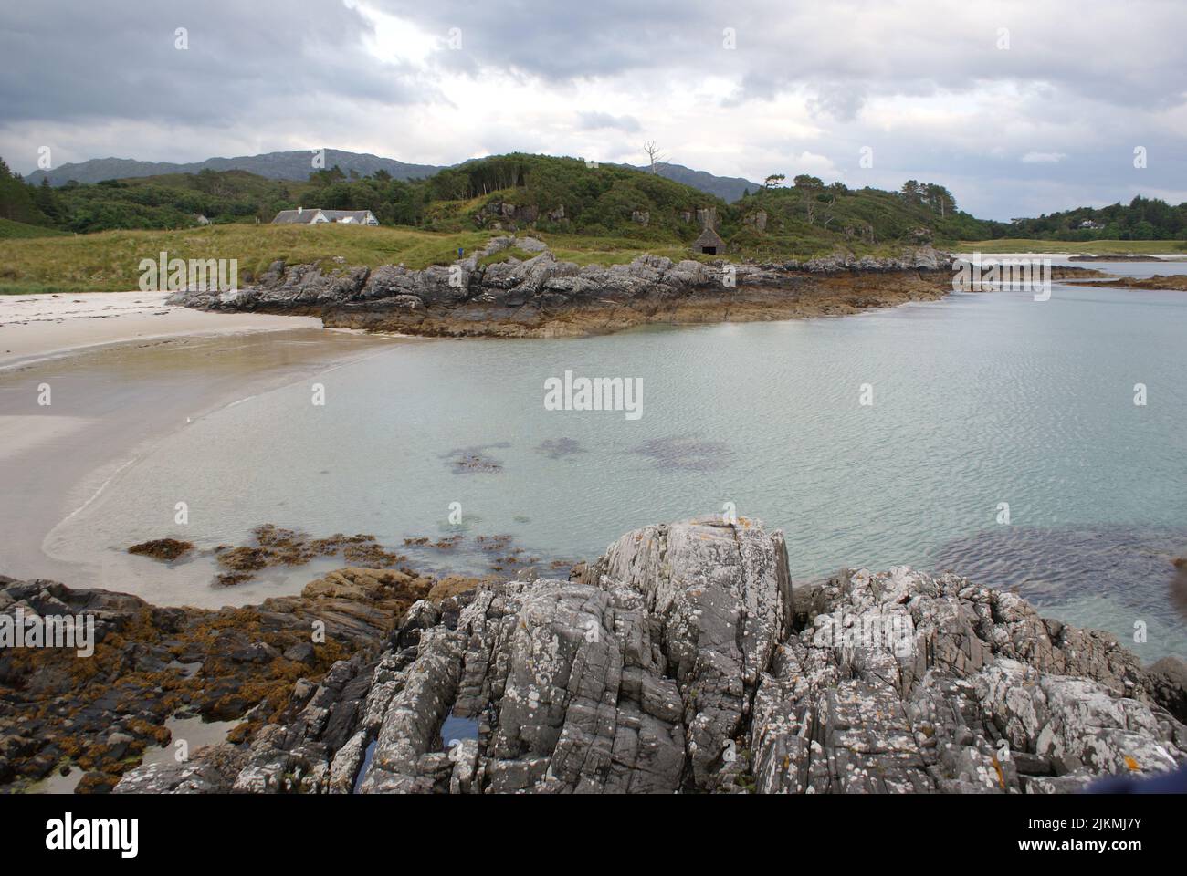 Una vista panoramica della costa rocciosa e del paesaggio montano in Scozia sotto un cielo nuvoloso Foto Stock