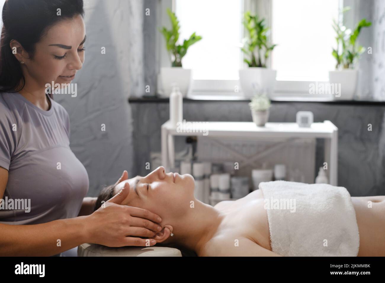 massaggio viso con olio in stile tradizionale realizzato da donne di bellezza professionisti. massaggio anti-età Foto Stock