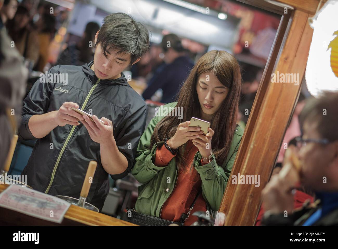Un primo piano di giovani distratti dai loro telefoni. Tainan, Taiwan. Foto Stock