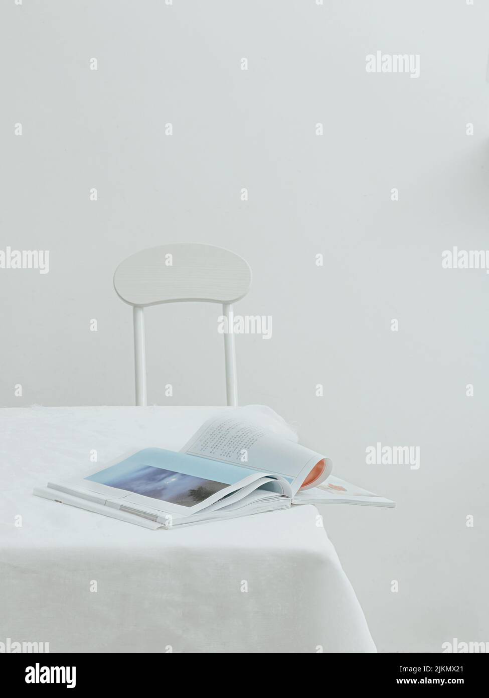 Una vista estetica di un giornale aperto su un tavolo con tovaglia bianca Foto Stock