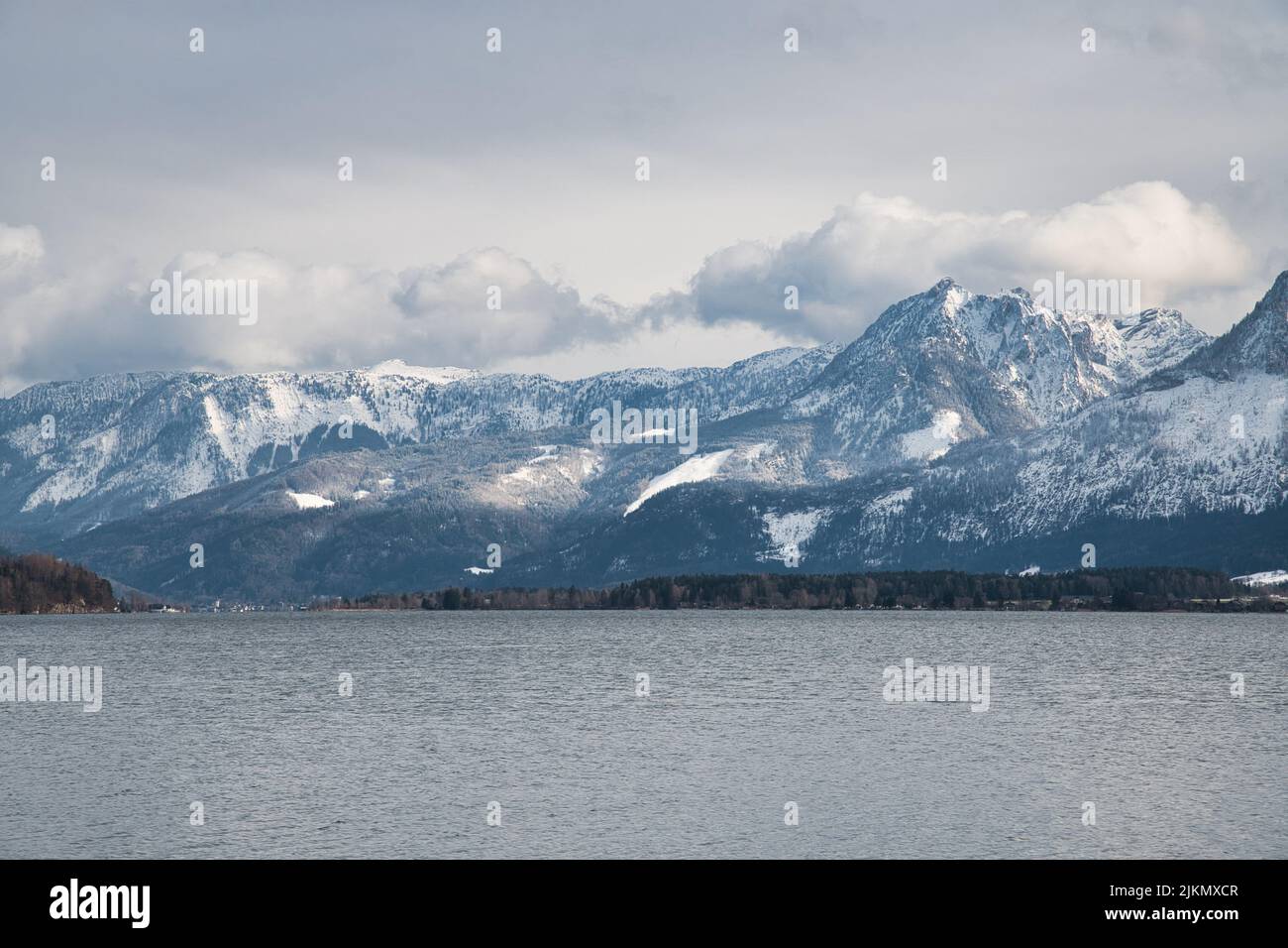 Una vista panoramica sul lago Wolfgangsee in Austria, circondato da montagne su uno sfondo di cielo nuvoloso Foto Stock