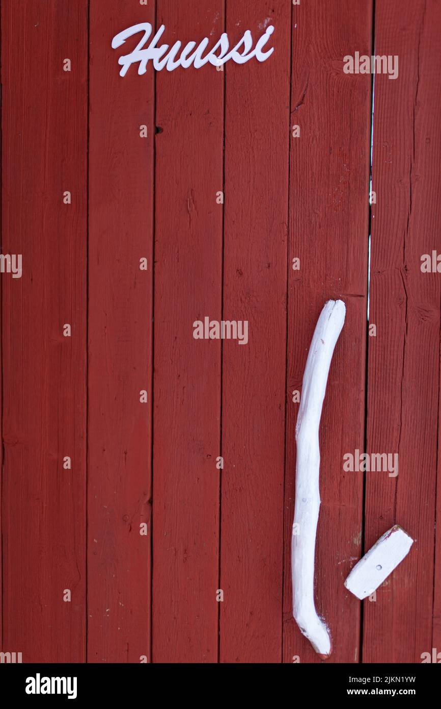 Un colpo verticale di porta rossa in legno con un'iscrizione bianca Foto Stock