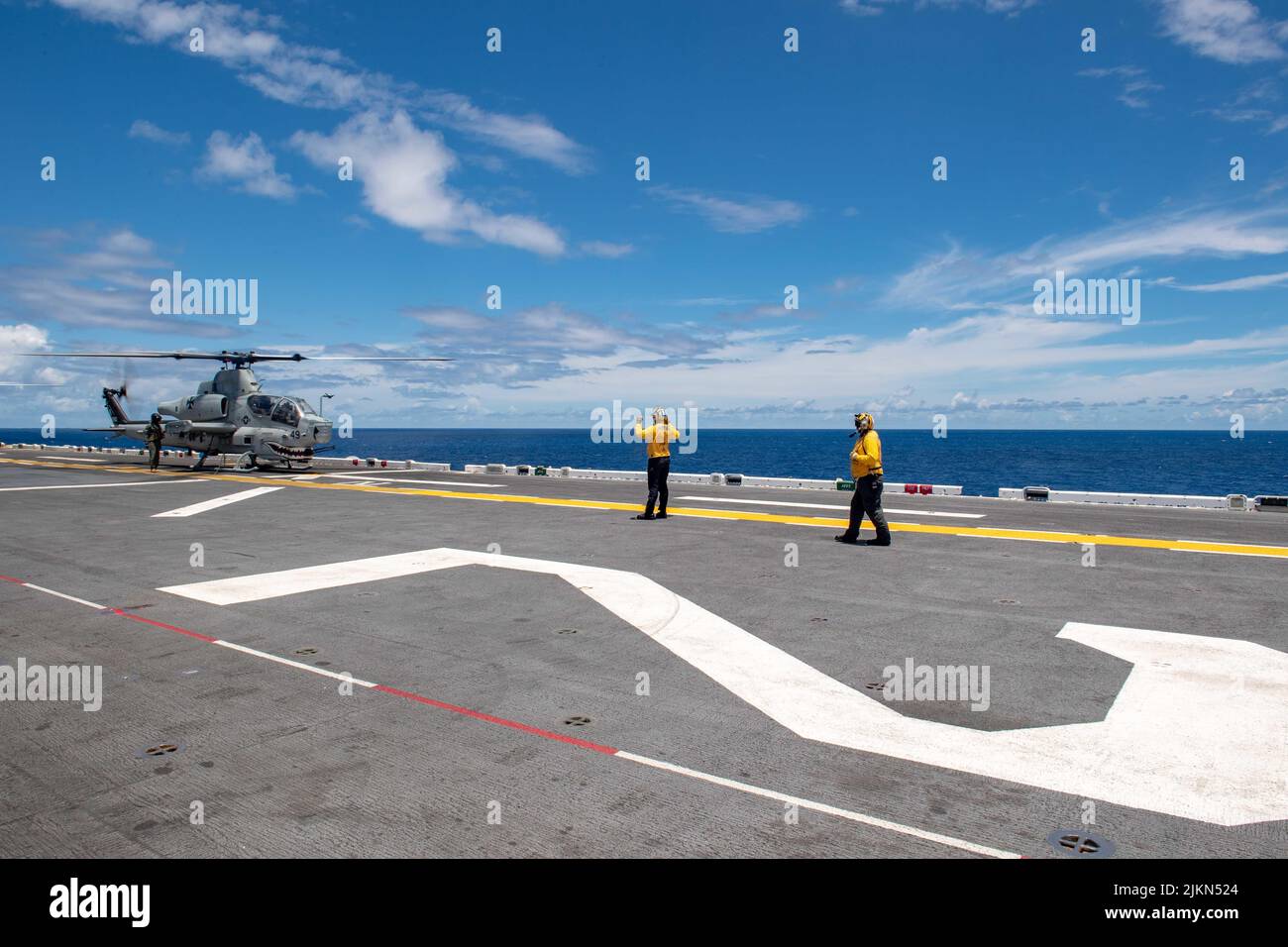 OCEANO PACIFICO (29 luglio 2022) U.S. Navy Airman Sean Manzer, a sinistra, sotto l'istruzione di U.S. Navy Aviation Boatswain's Mate (Handling) 3rd Classe Martin Carvajan segnala a un AH-1Z Viper, attaccato a Marine Light Attack Helicopter Squadron (HMLA) 169, Sul ponte di volo della nave d'assalto anfibio USS Essex di classe Wasp della Marina degli Stati Uniti (LHD 2) a sostegno di un esercizio di operazioni anfibie durante il Rim of the Pacific (RIMPAC) 2022, luglio 29. Ventisei nazioni, 38 navi, tre sottomarini, più di 170 aerei e 25.000 persone partecipano al RIMPAC dal giugno 29 al 4 agosto all'interno e intorno all'Hawai Foto Stock