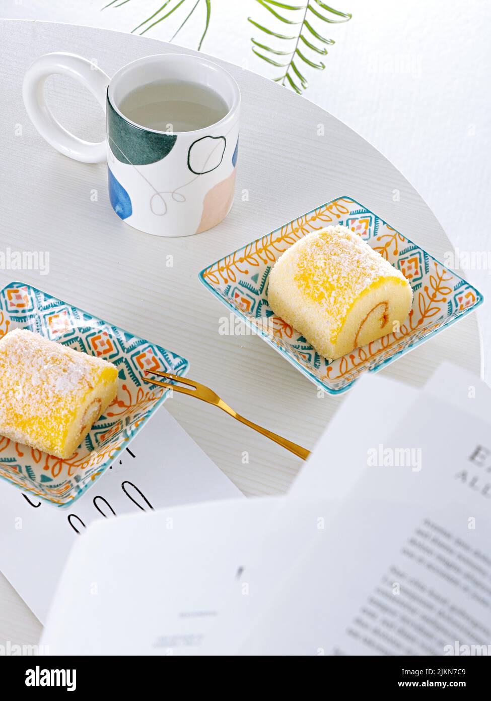 Una foto verticale di allestimento da tavolo con dessert svizzero e una tazza di tè Foto Stock