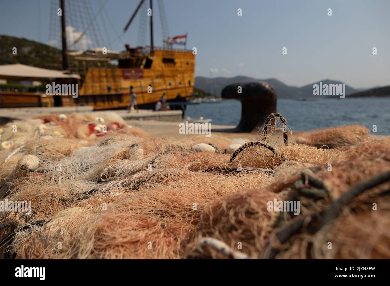 Rete di pesci sul porto dell'isola di Sipan accanto alla barca da pesca con la vecchia barca Karaka sul retro. Foto Stock