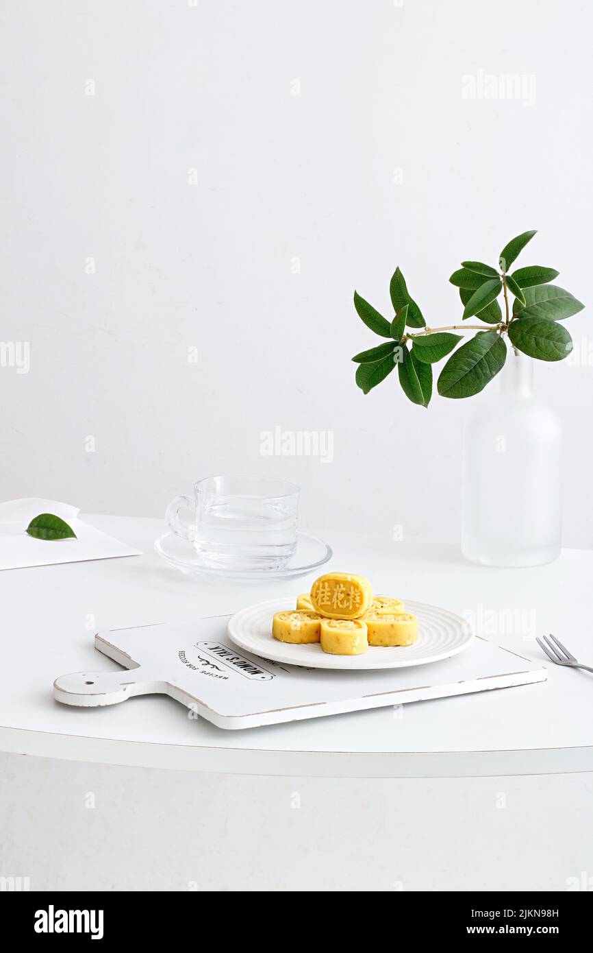 Un colpo verticale di allestimento da tavolo estetico con tradizionale torta di osmanthus cinese Foto Stock