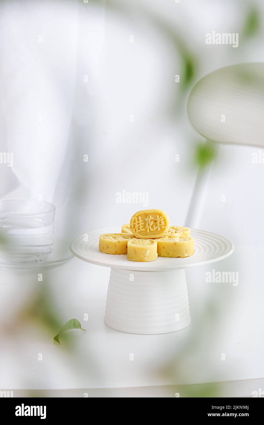 Un colpo verticale di allestimento da tavolo estetico con tradizionale torta di osmanthus cinese Foto Stock