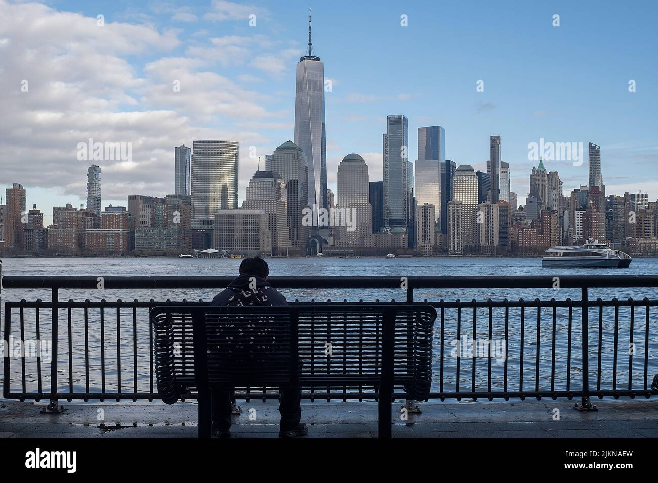 Una persona seduta su una panchina che si affaccia su New York, USA Foto Stock