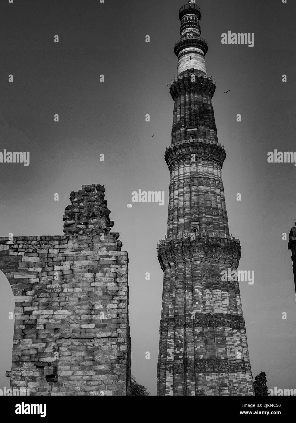 Una scala di grigi di una bella torre Qutab Minar a Nuova Delhi, India Foto Stock