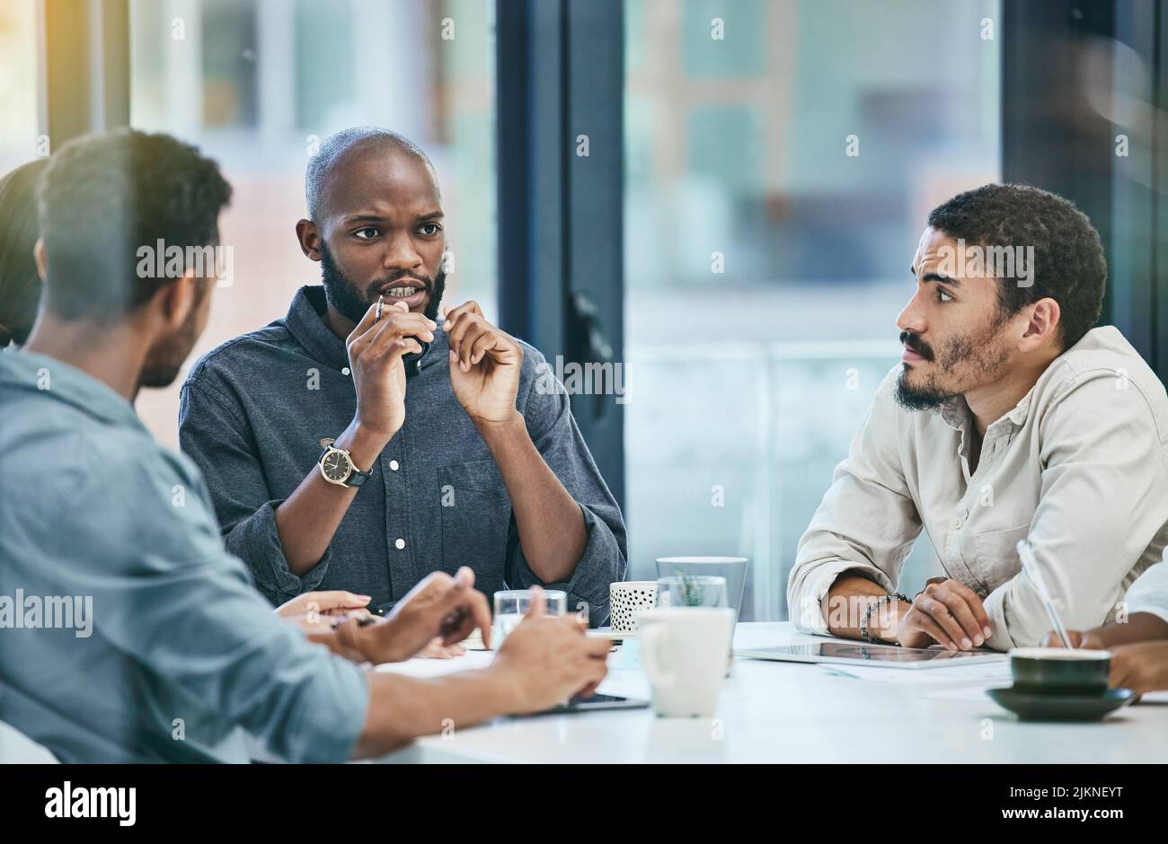 Dobbiamo lavorare di più sulla nostra strategia: Un gruppo di colleghi in una riunione d'affari. Foto Stock