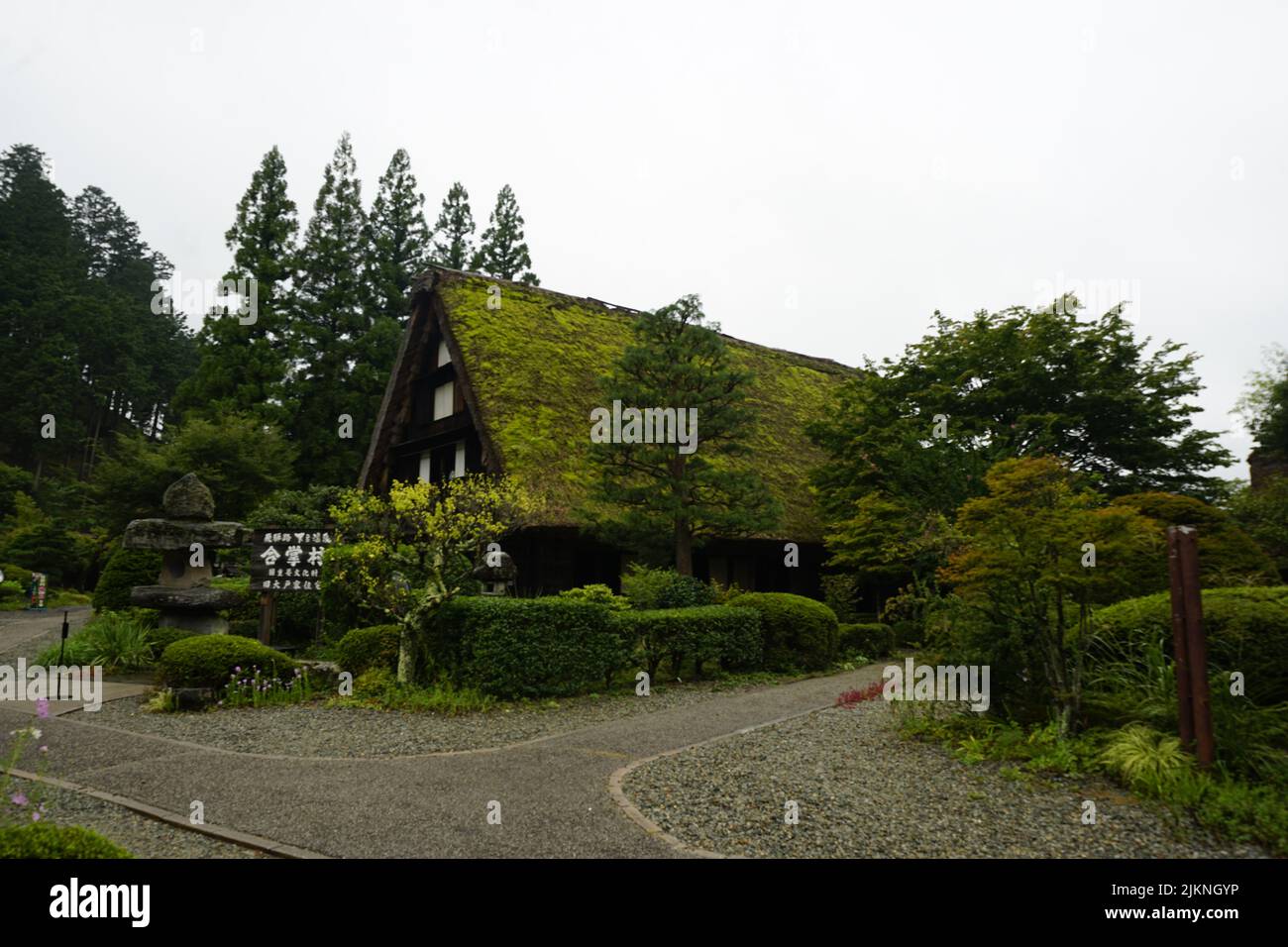 Una casa verde in stile gassho-zukuri circondata da alberi e cespugli nel Gassho Village Gero Onsen Foto Stock