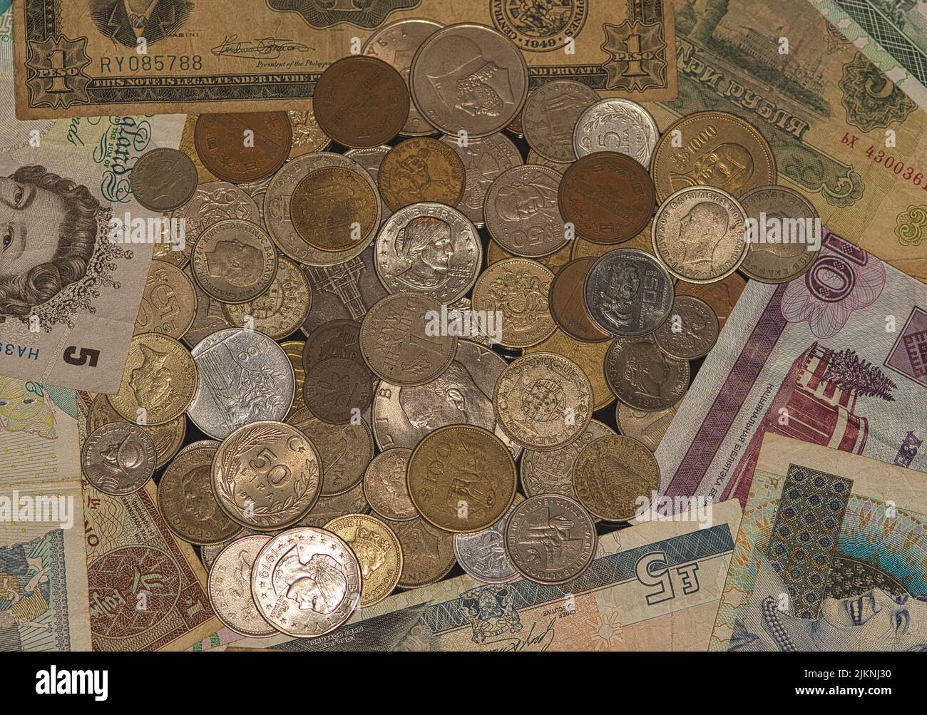 Una vista dall'alto di una pila di vecchie monete e carta moneta - numismatica Foto Stock