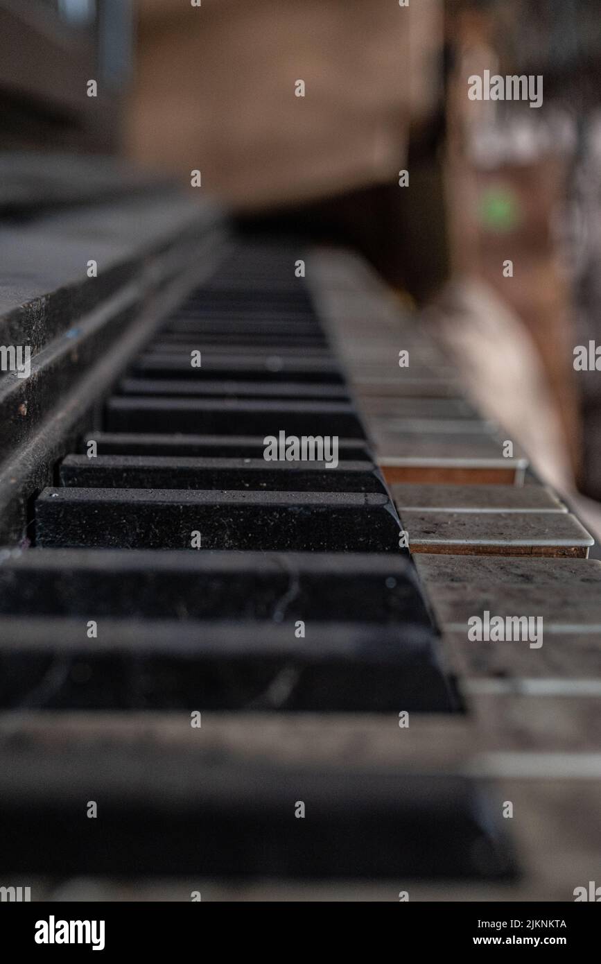 Un pianoforte d'epoca rotto con le chiavi sporche del pianoforte in un magazzino abbandonato Foto Stock