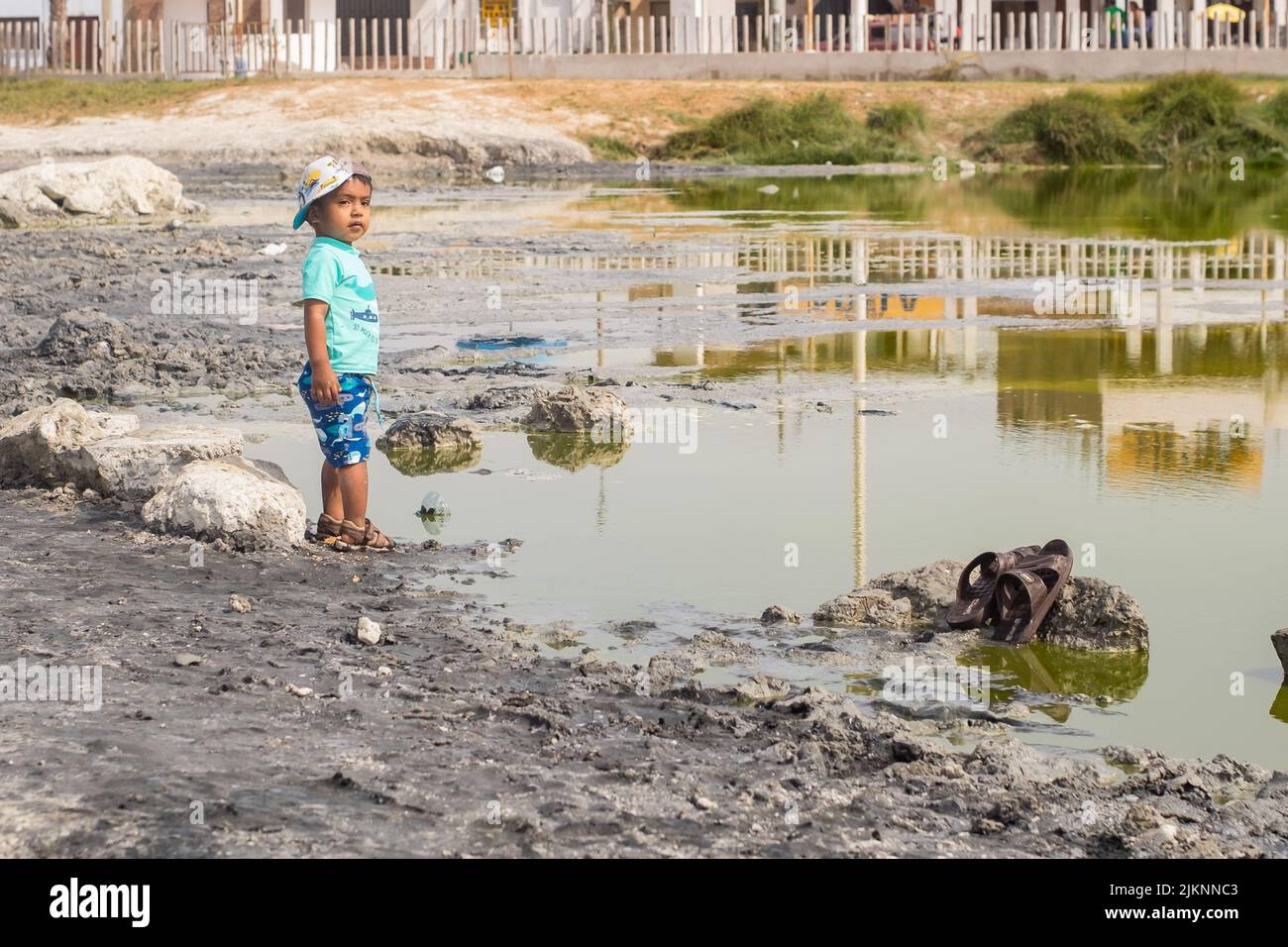 Un ragazzo latino che guarda verso una laguna naturale dove viene praticata la fangoterapia Foto Stock