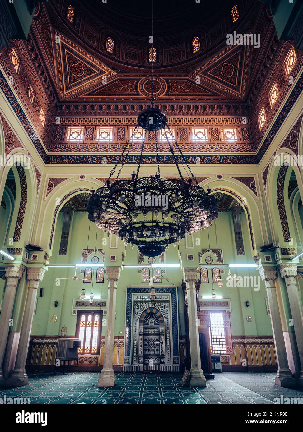 Una foto verticale della nicchia della moschea, un grande lampadario e il dettaglio interno di una moschea durante il giorno ad Assuan, Egitto Foto Stock