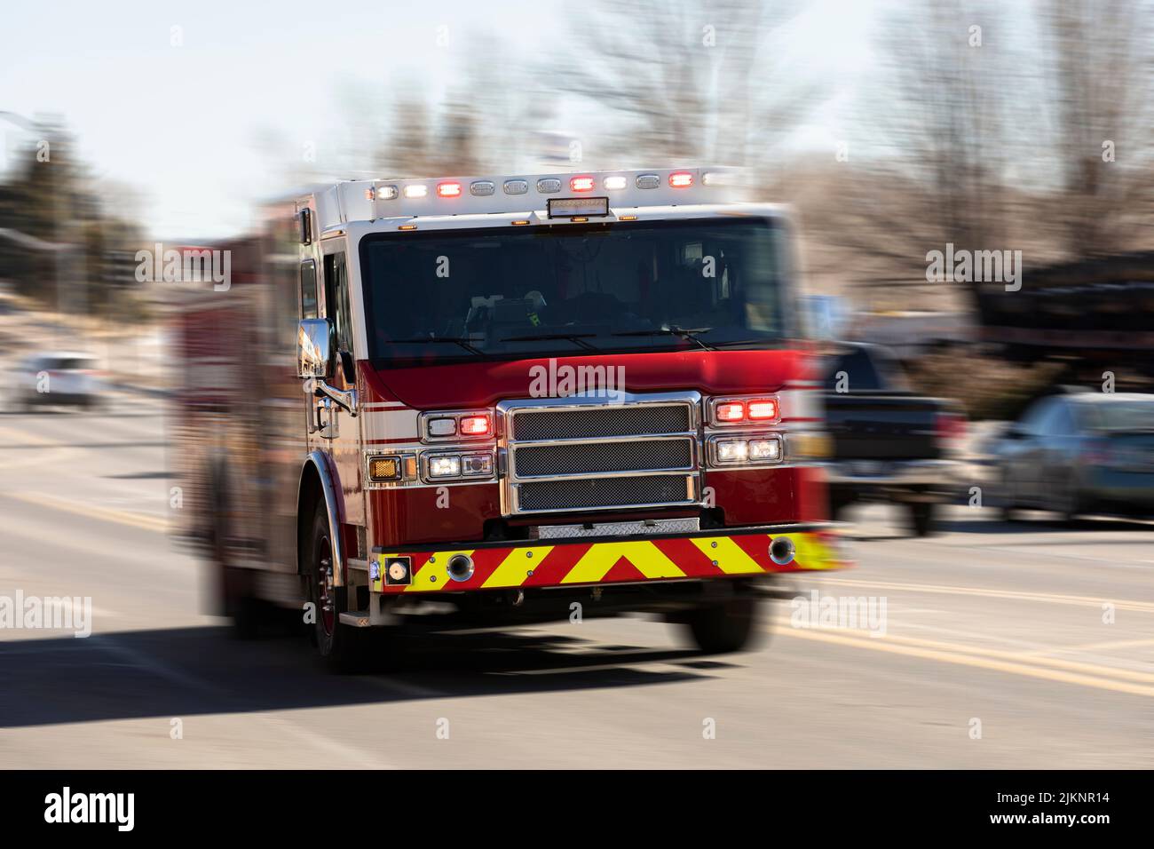 Vista panoramica del movimento di un camion dei vigili del fuoco con sirene che sparano sulla scena di un'emergenza. Foto Stock