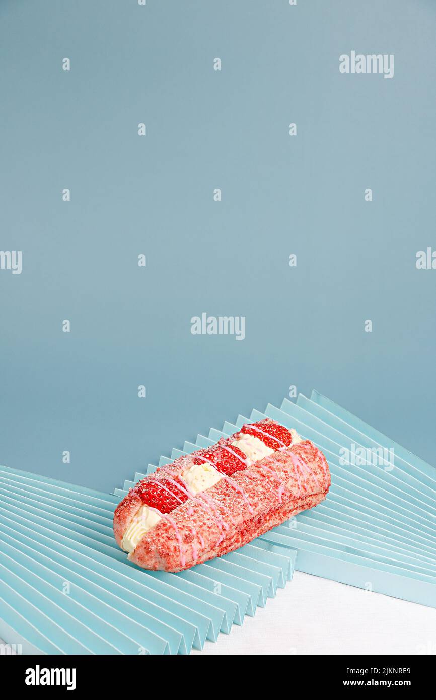 Un delizioso dessert con crema e fragole su sfondo blu Foto Stock