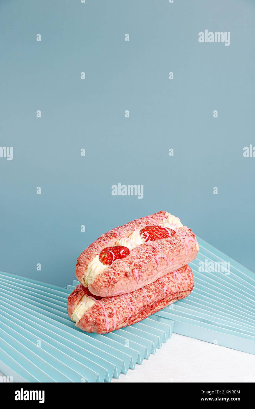 Un delizioso dessert con crema e fragole su sfondo blu Foto Stock