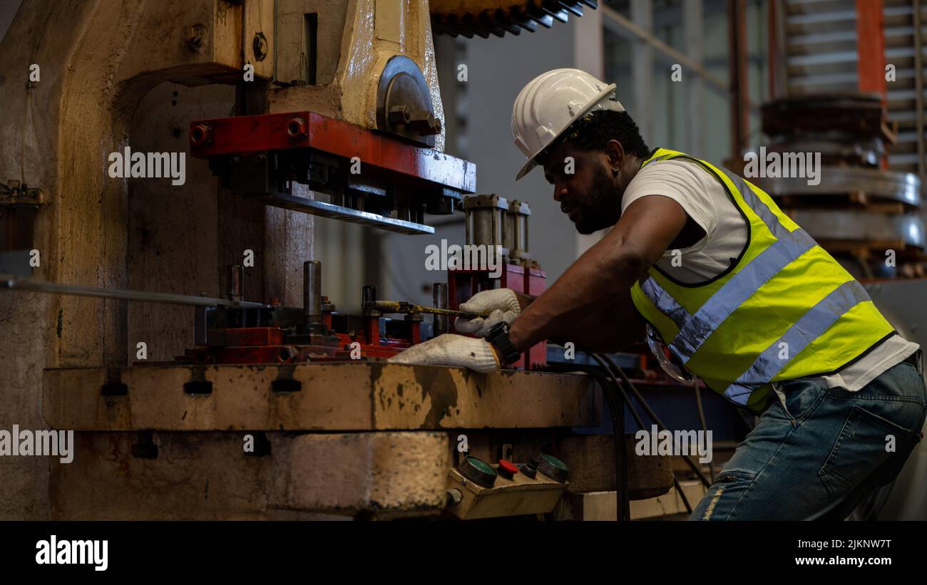 Heavy Industry Foreman Engineer ware giubbotto di sicurezza manutenzione preventiva giornaliera macchina di controllo in fabbrica di produzione, utilizzare appunti, hanno discussione Foto Stock