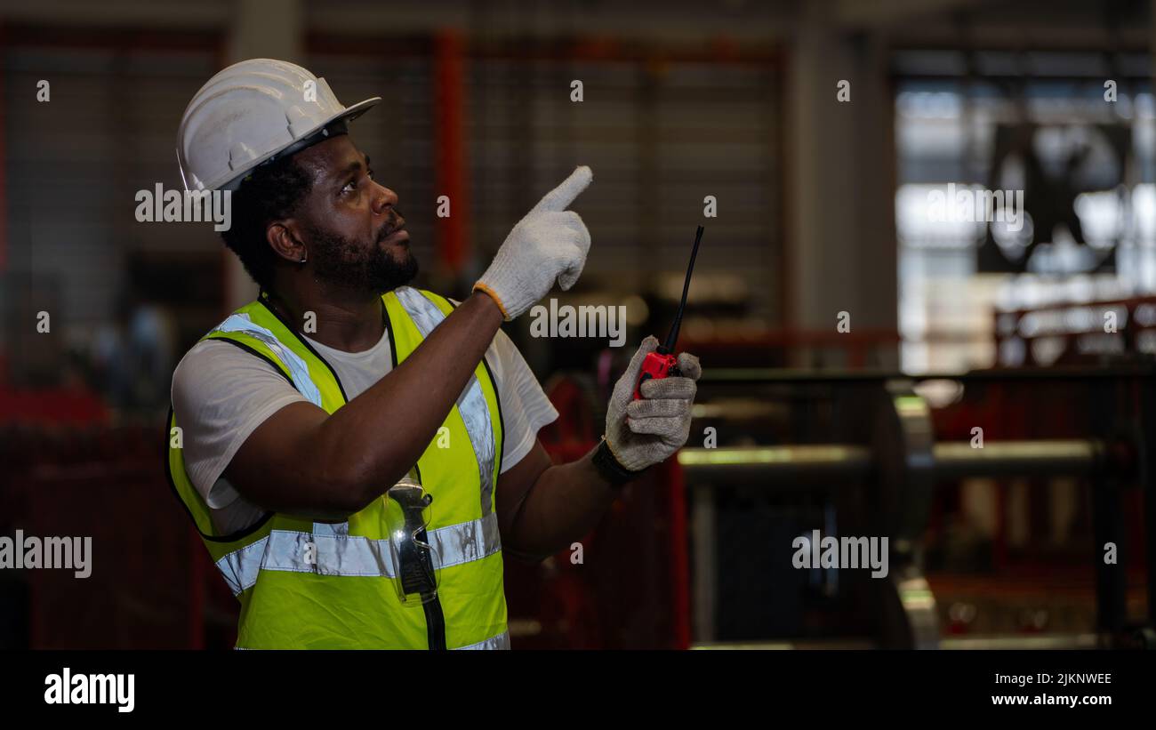 Heavy Industry Foreman Engineer ware giubbotto di sicurezza manutenzione preventiva giornaliera macchina di controllo in fabbrica di produzione, utilizzare appunti, hanno discussione Foto Stock