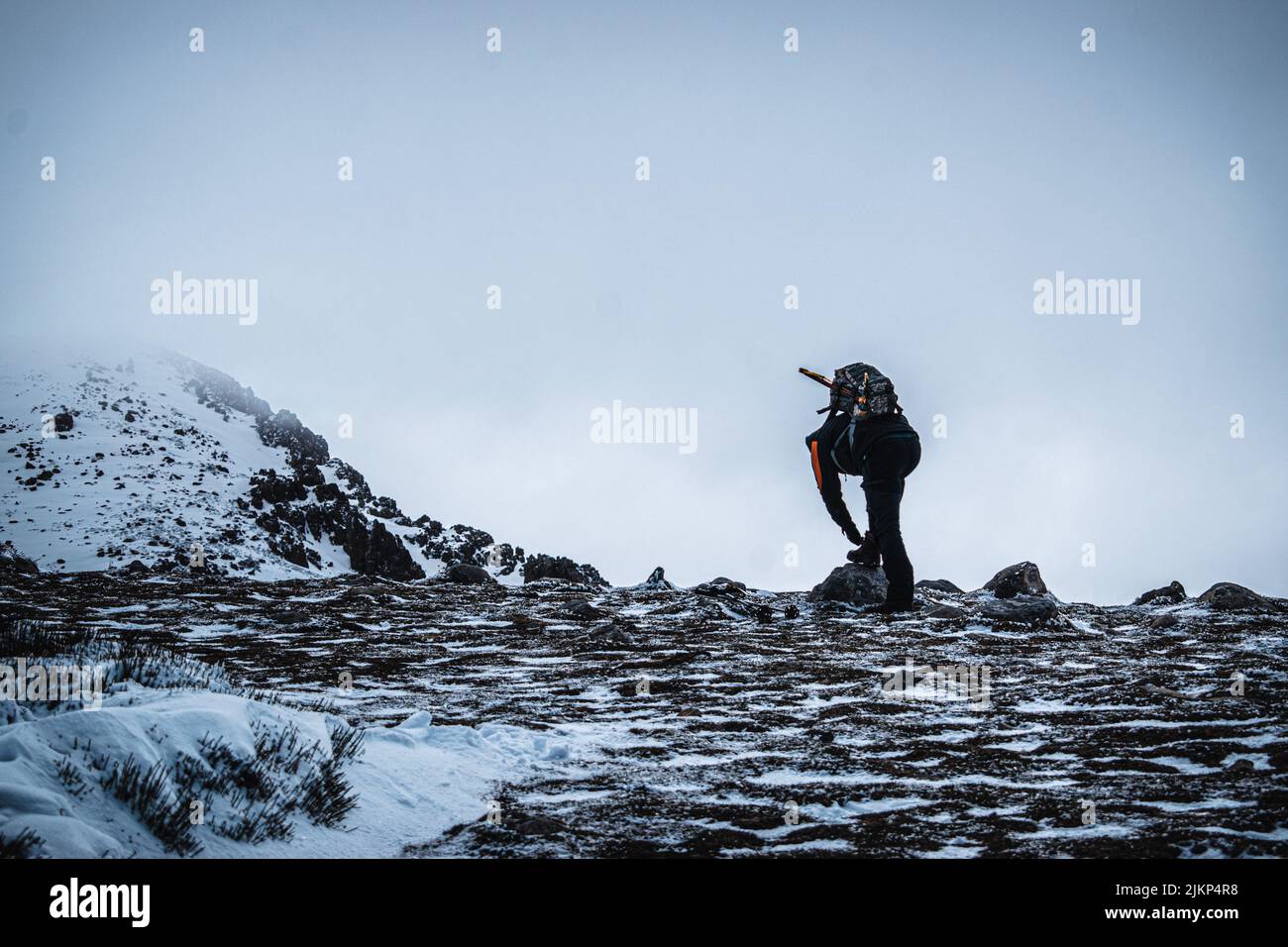L'arrampicatore ha regolato gli scarponi per salire la montagna Foto Stock