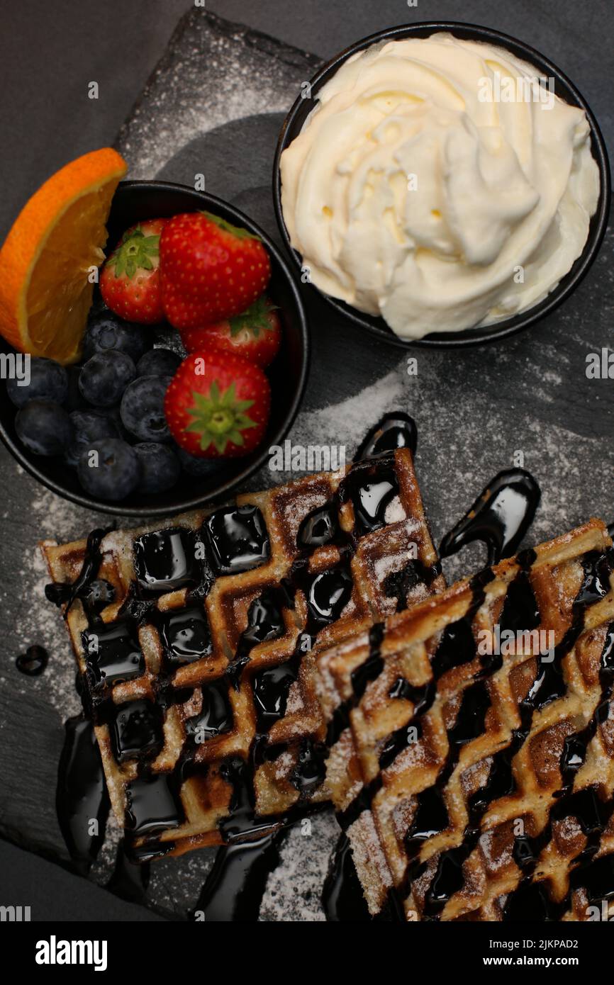 Una vista dall'alto dei waffle belgi con gelato allo sciroppo d'acero e frutti di bosco Foto Stock