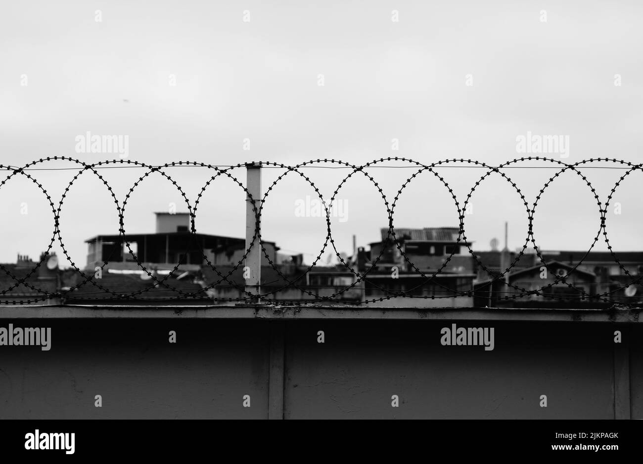 Un'immagine in scala di grigi di un filo metallico barbato sul punto di vista contro il cielo limpido Foto Stock