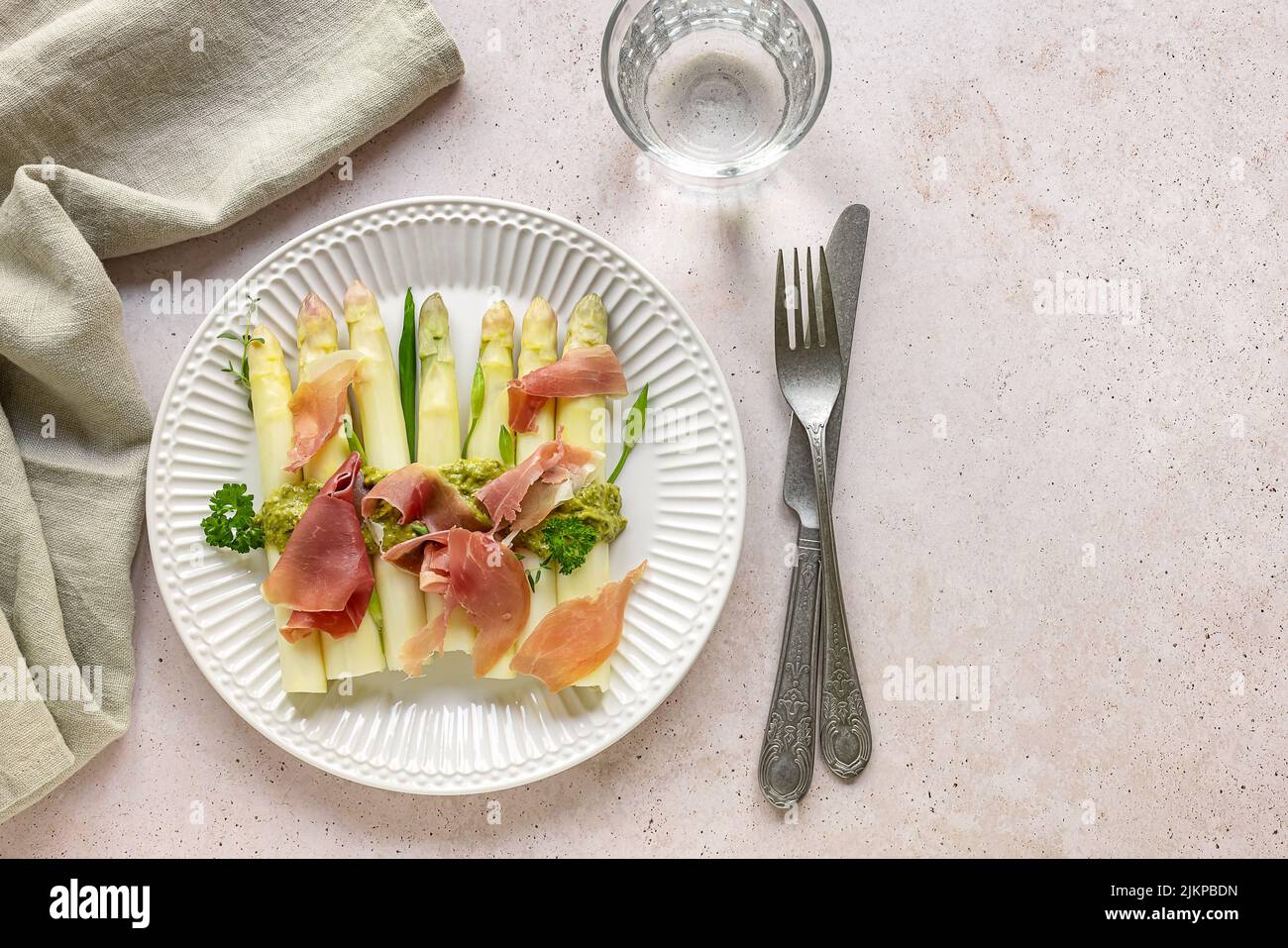 Asparagi bianchi con pesto e prosciutto italiano. Deliziosa cena per la stagione primaverile. Foto Stock