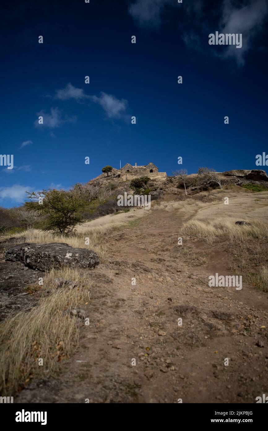 Uno scatto verticale dell'inizio di una montagna rocciosa nella luce del giorno sotto il cielo blu Foto Stock