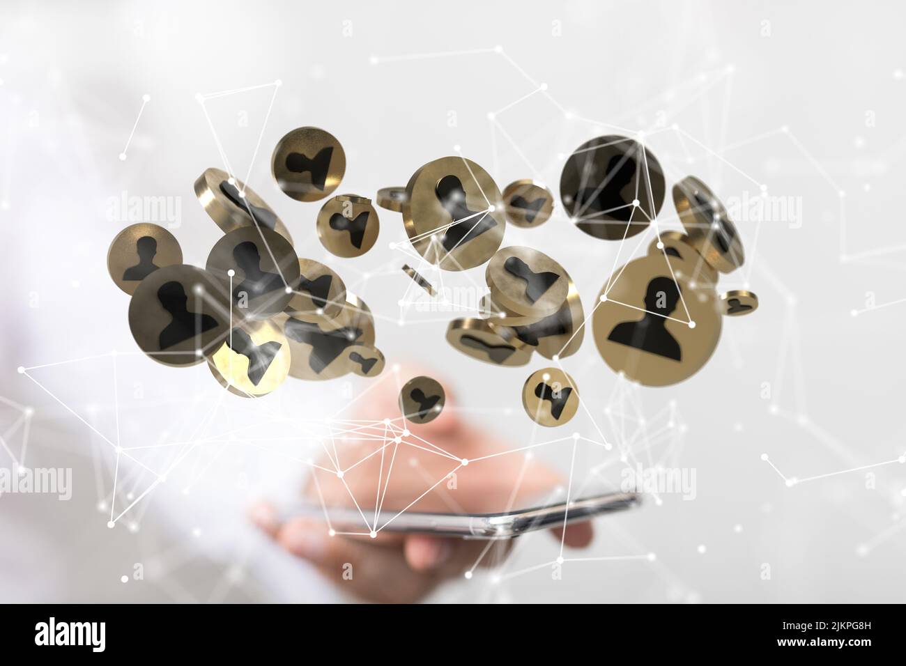 Monete marroni rotonde con icone di persona sullo sfondo di una mano sfocata di una persona che tiene un telefono. Concetto di digitalizzazione Foto Stock