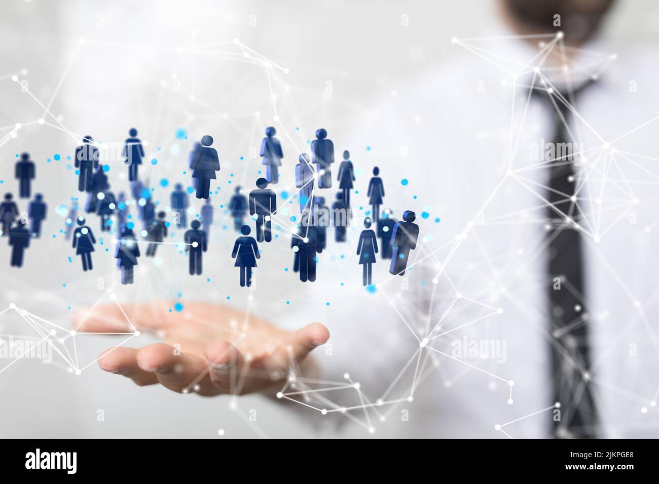 Un grafico di rete illustrato con icone blu sopra la mano di una persona durante una presentazione Foto Stock