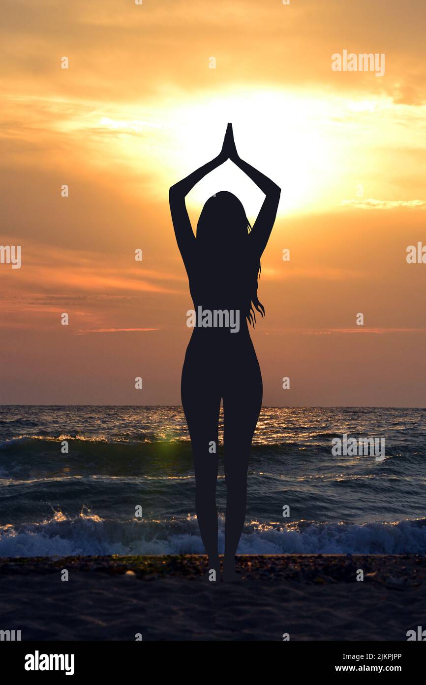 Meditando e facendo yoga in spiaggia all'alba Foto Stock
