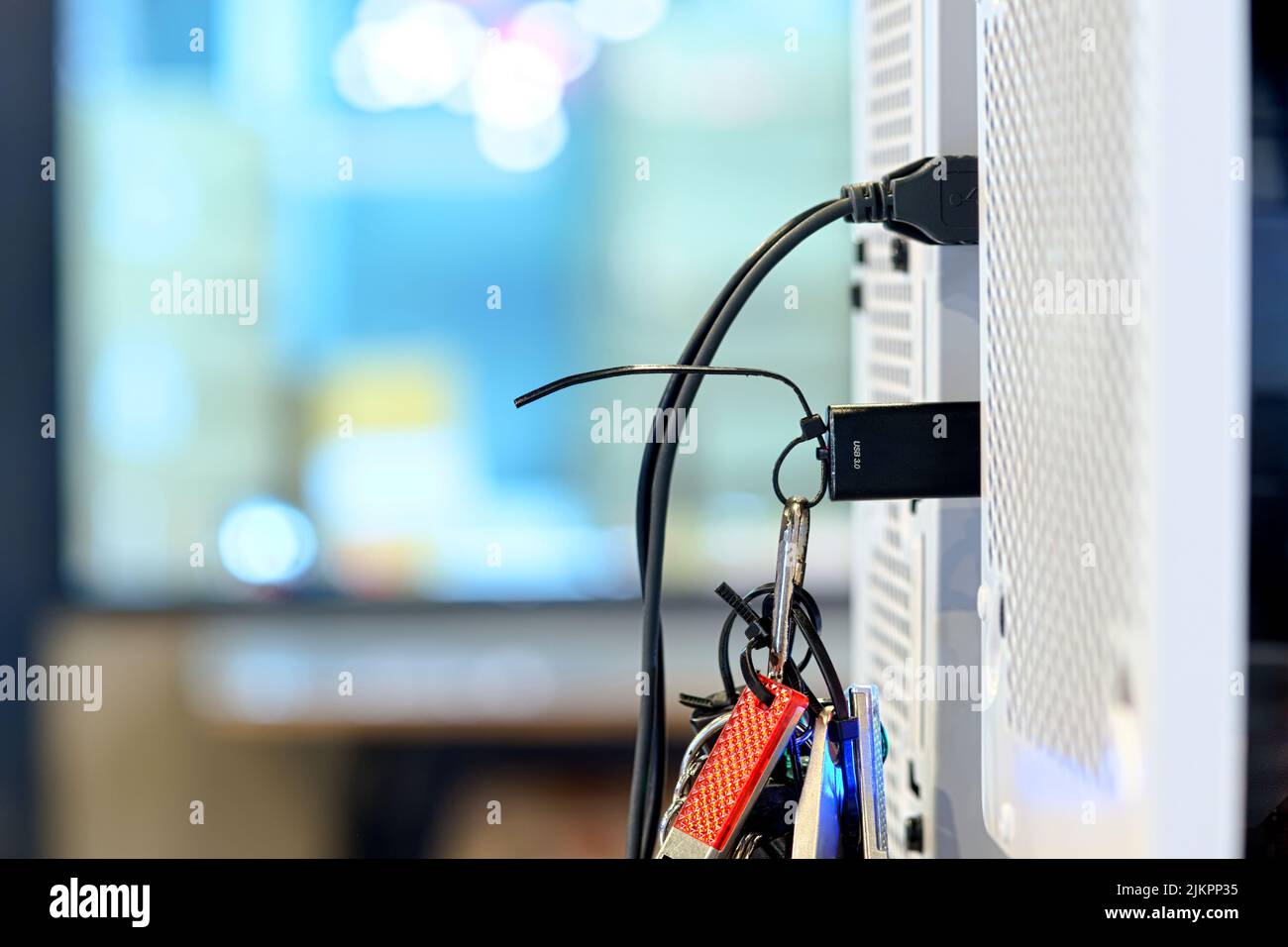 L'unità flash USB 3,0 nera con messa a fuoco selettiva si collega alla porta USB sulla scheda madre del PC desktop per trasferire i dati su sfondo sfocato Foto Stock