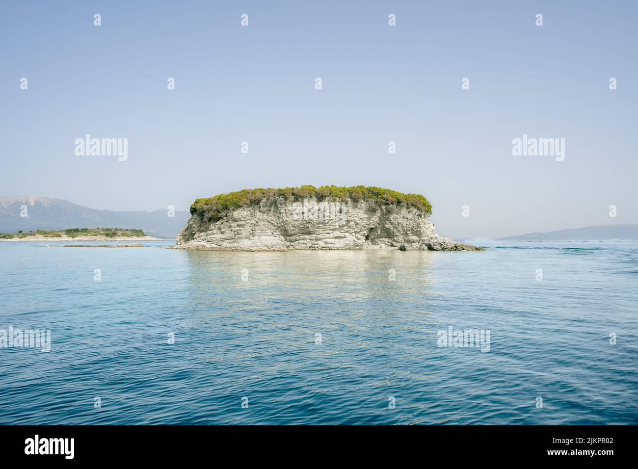 Uno scenario da una barca di Meganisi, Grecia, con mini isole rocciose e paesaggi acquatici Foto Stock