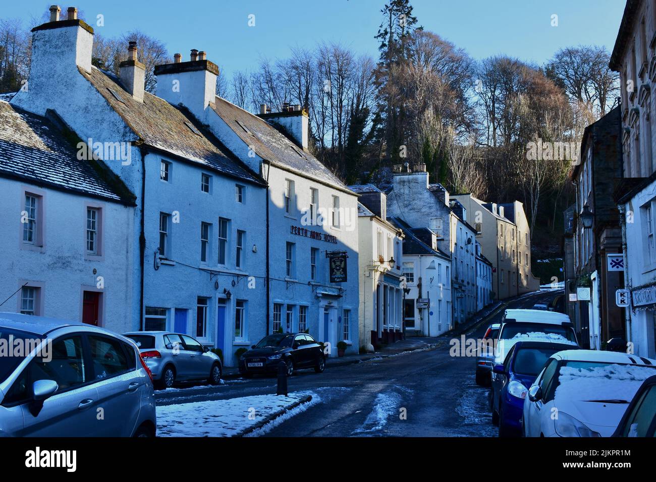 Una vista invernale lungo High Street a Dunkeld con il Perth Arms Hotel nel centro. La neve del mattino presto copre le strade. Foto Stock